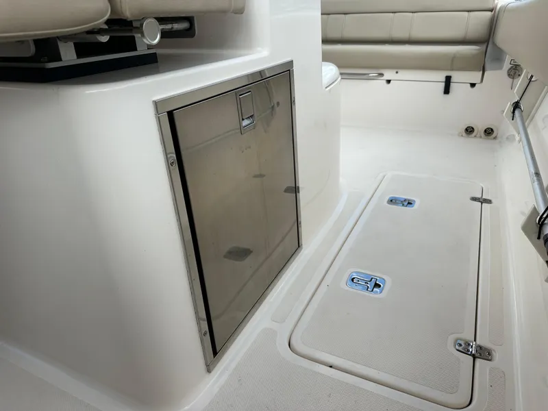 Slide: The Image of Interior of a 2015 Pursuit ST 310 Sport boat, featuring seating and storage compartments. - 18