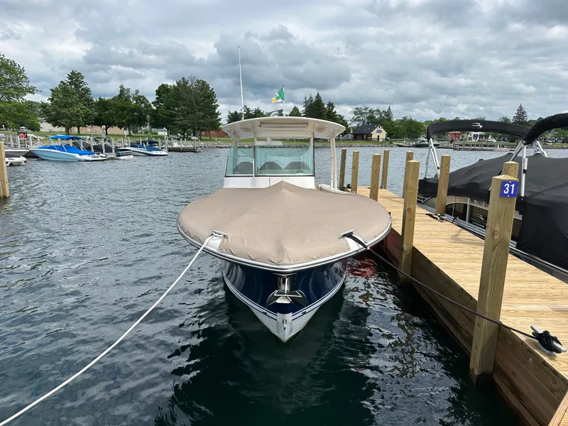 Slide: The Image of 2015 Pursuit ST 310 Sport boat docked at marina, covered and secured. - 2