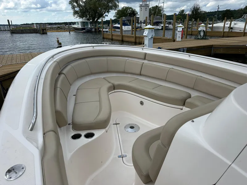 Slide: The Image of 2015 Pursuit ST 310 Sport boat with beige seating at a marina dock. - 6