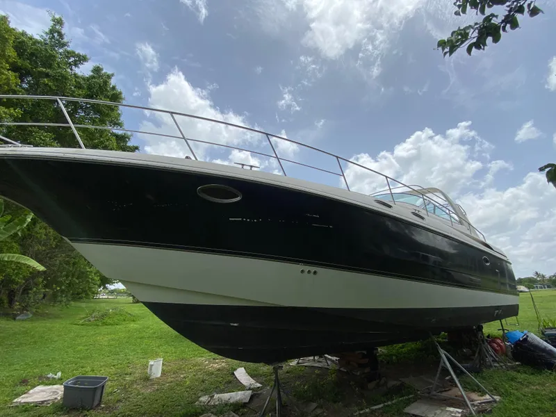 Slide: The Image of 2000 Cruisers Yachts 3870 Express on land, under a cloudy sky. - 11
