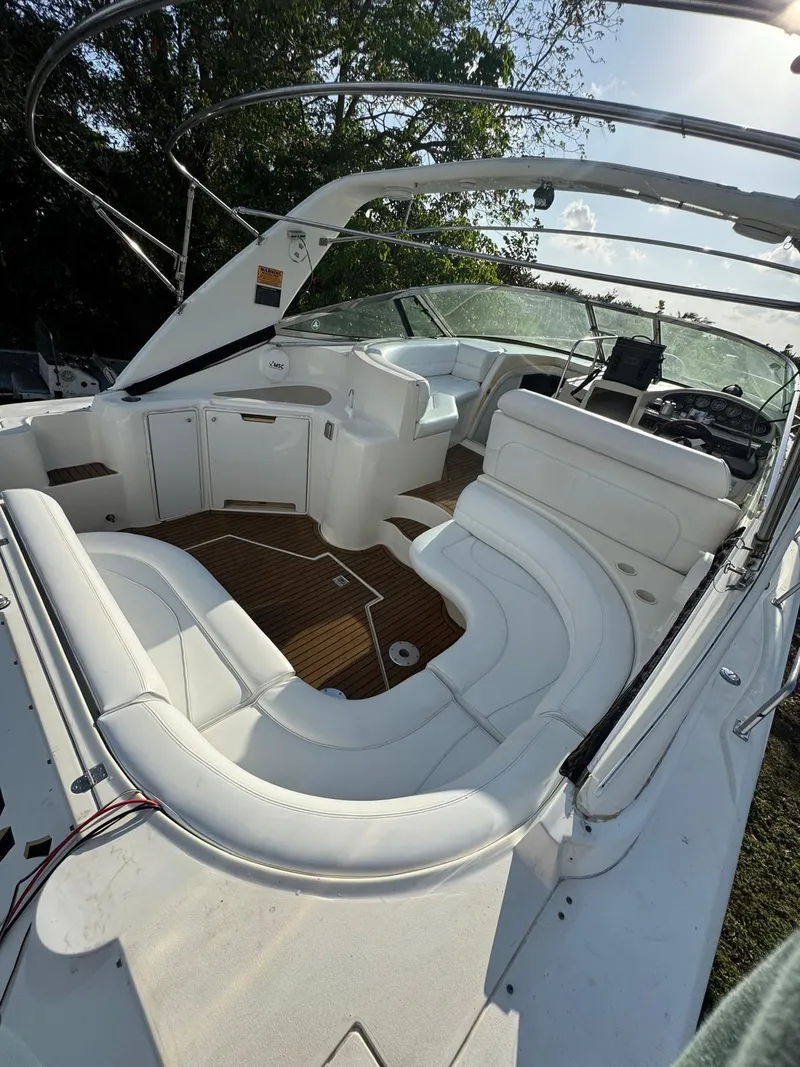 Slide: The Image of 2000 Cruisers Yachts 3870 Express with white seating and wooden deck, docked outdoors. - 13