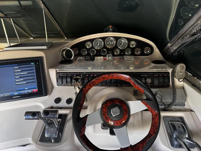Slide: The Image of Cockpit of 2000 Cruisers Yachts 3870 Express with steering wheel and navigation controls. - 15
