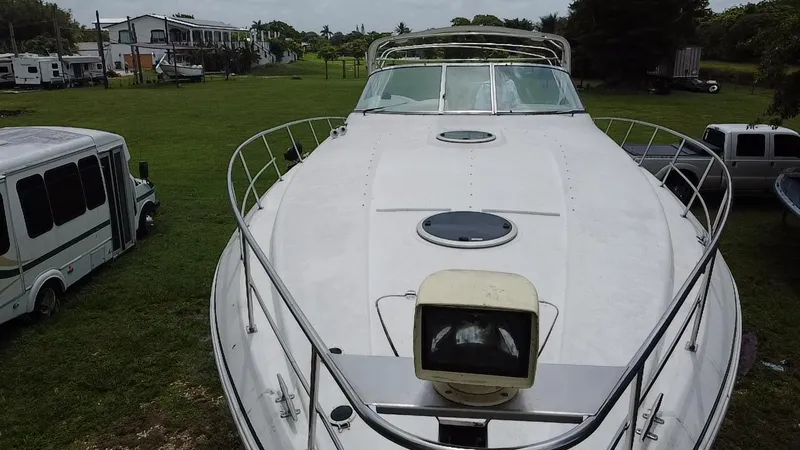 Slide: The Image of 2000 Cruisers Yachts 3870 Express boat on grassy area, surrounded by vehicles. - 8