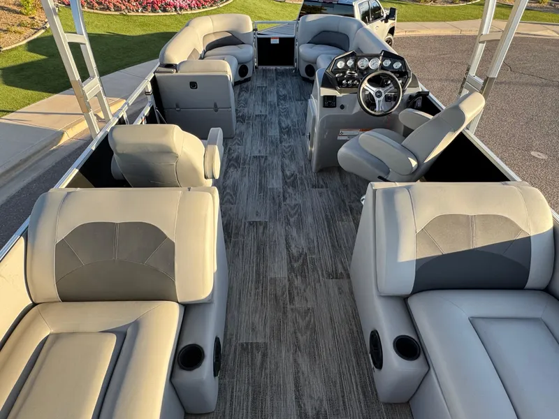 Slide: The Image of 2024 Landau Island Breeze 252 pontoon boat interior with gray seating and modern dashboard. - 10
