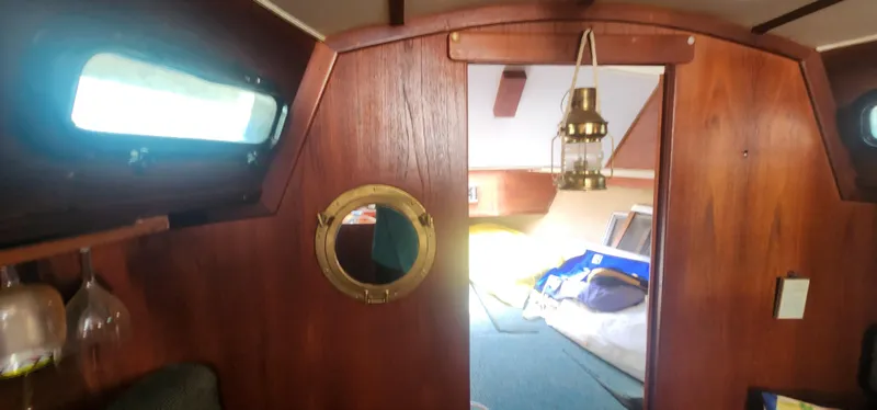 Slide: The Image of Interior of 1984 Caliber 28 sailboat with wooden paneling and nautical decor. - 10