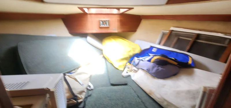 Slide: The Image of Interior cabin of a 1984 Caliber 28 sailboat with cushions and gear. - 11