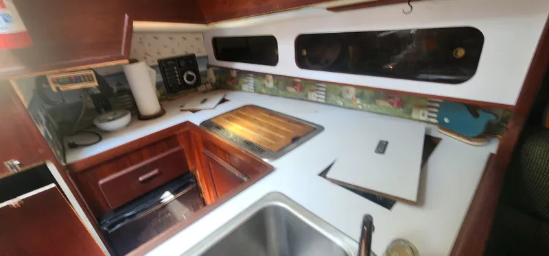 Slide: The Image of 1984 Caliber 28 yacht kitchen with wooden cabinets, sink, and countertop. - 12