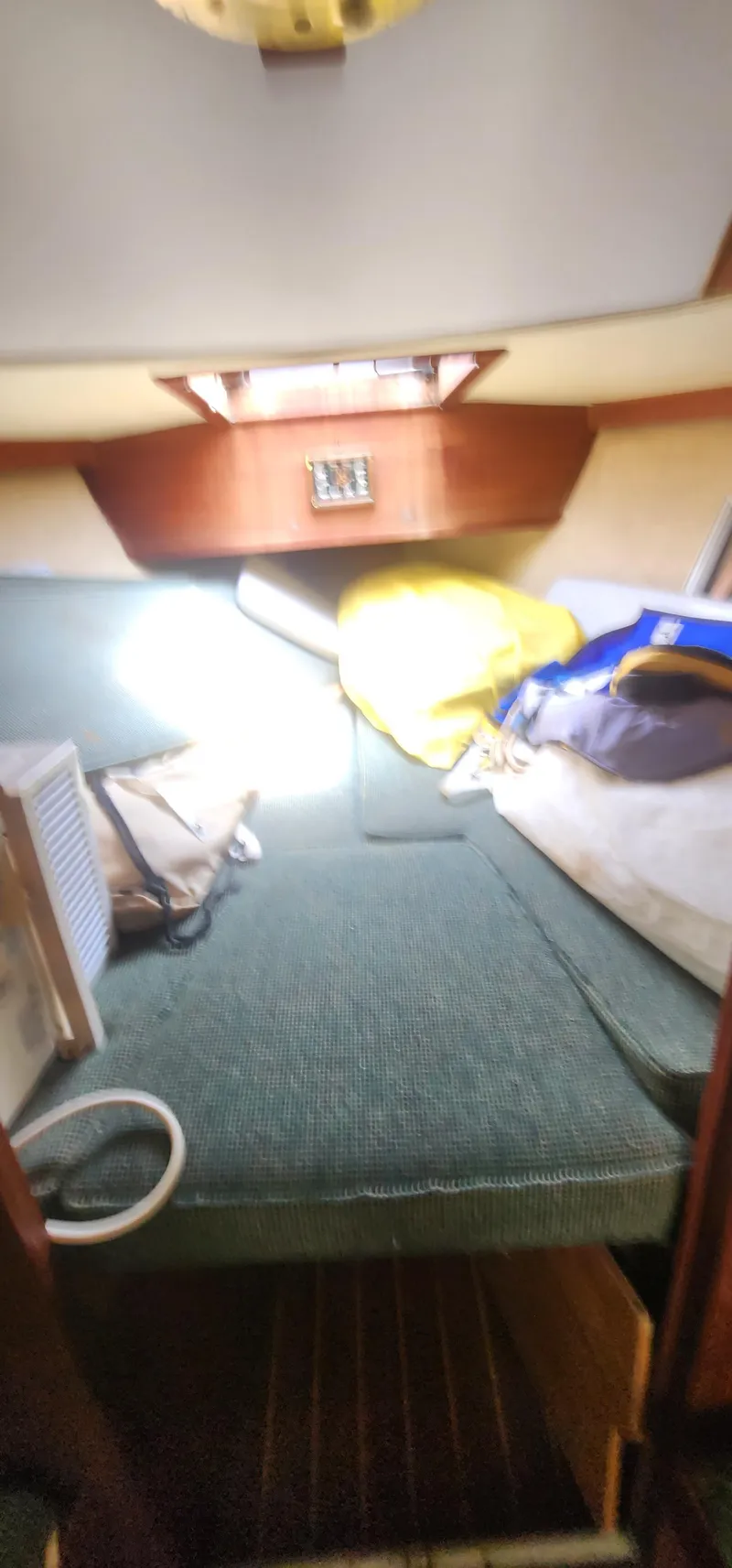 Slide: The Image of Cozy interior of a 1984 Caliber 28 sailboat with green seating and storage. - 13