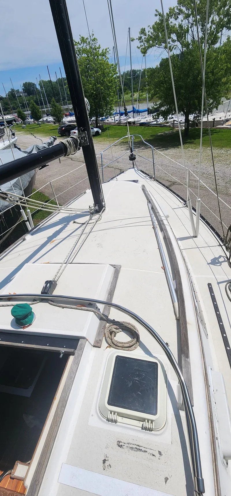 Slide: The Image of 1984 Caliber 28 sailboat deck view with mast and rigging in a marina setting. - 17