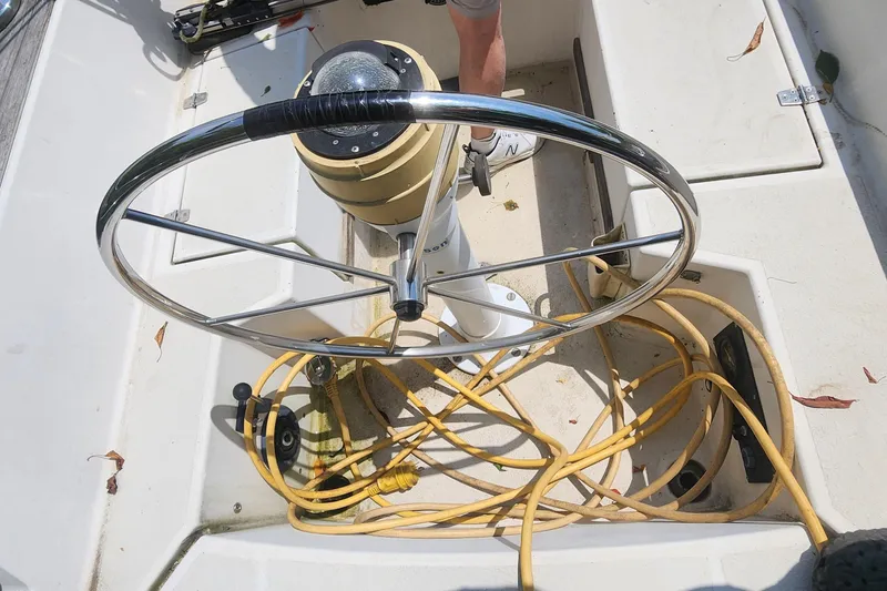 Slide: The Image of Steering wheel of a 1984 Caliber 28 sailboat with coiled yellow rope. - 25
