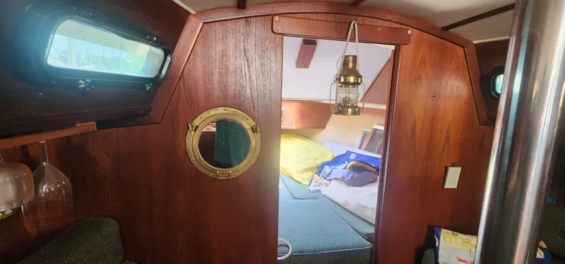 Slide: The Image of Interior of 1984 Caliber 28 sailboat with wooden paneling and cozy cabin space. - 7