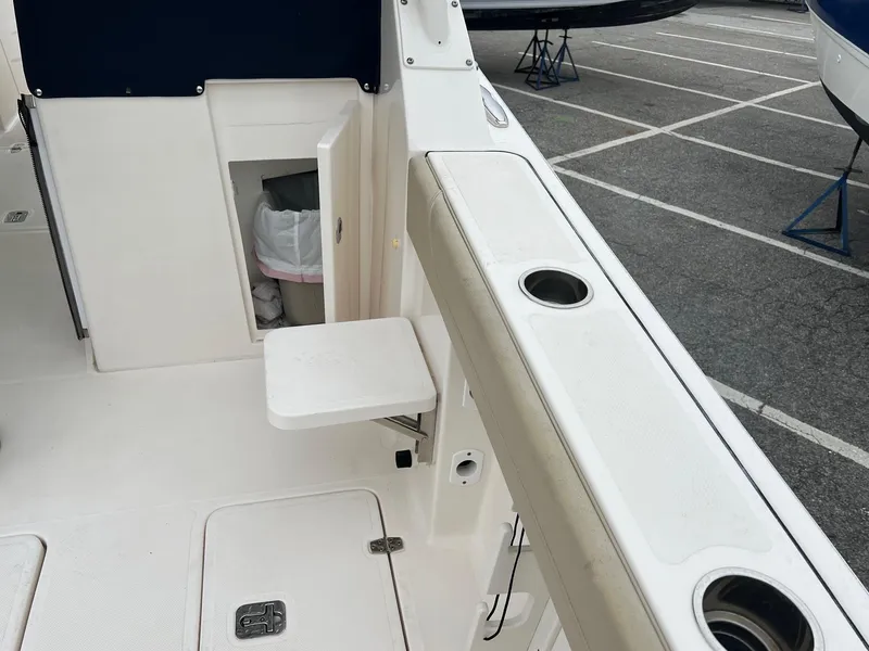 Slide: The Image of 2016 Pursuit 325 DC boat interior with storage compartment and cup holders. - 12