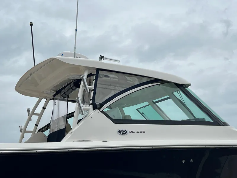 Slide: The Image of 2016 Pursuit 325 DC boat with sleek design against cloudy sky. - 2