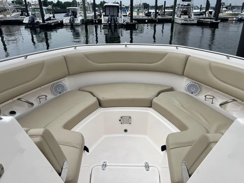Slide: The Image of 2016 Pursuit 325 DC boat interior with beige seating at marina. - 24