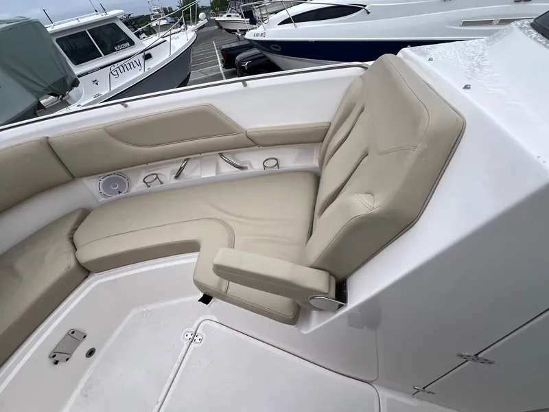 Slide: The Image of 2016 Pursuit 325 DC boat interior with beige seating and cup holders. - 25