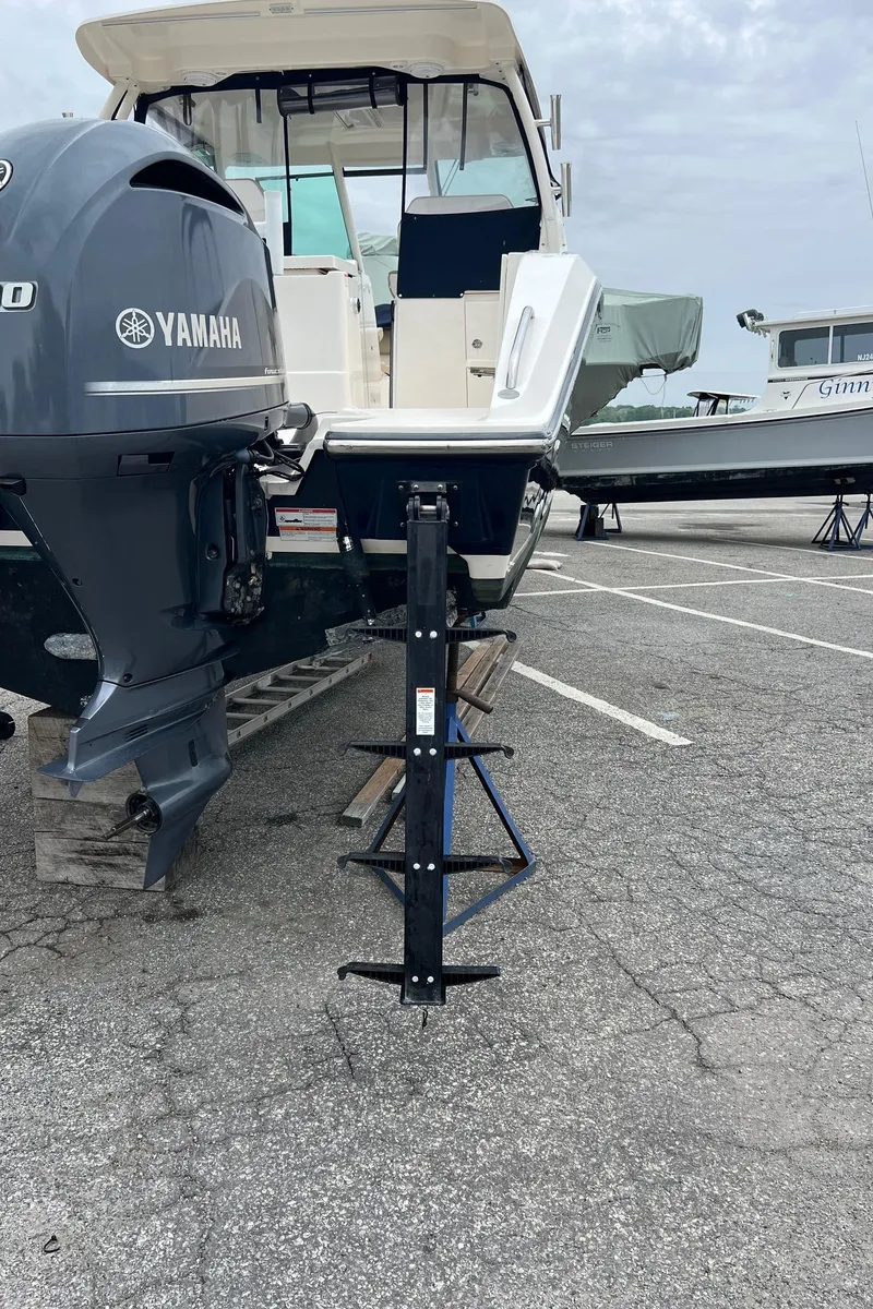 Slide: The Image of 2016 Pursuit 325 DC boat with Yamaha engine on a trailer in a parking lot. - 6