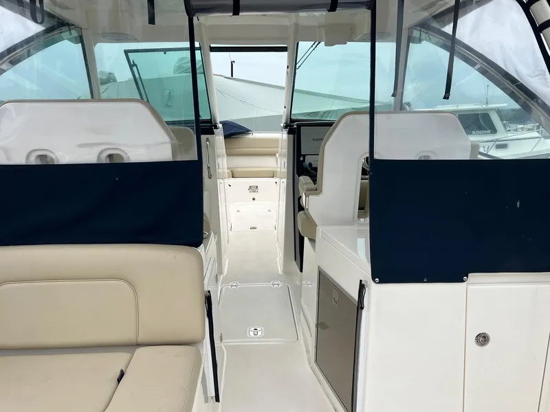 Slide: The Image of 2016 Pursuit 325 DC boat interior with seating and navigation area. - 7