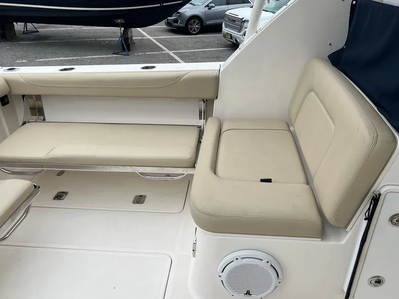 Slide: The Image of 2016 Pursuit 325 DC boat interior with beige seating and speaker. - 9