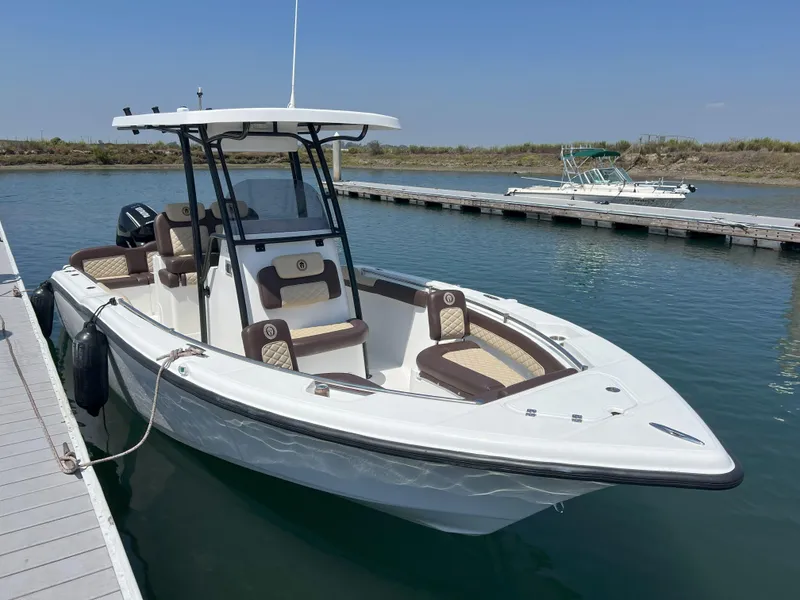 The Image of 2026 Reflex Gladiator 2400 boat docked on calm water, featuring sleek design and modern seating. - 0