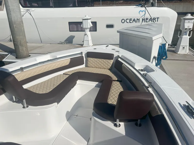Slide: The Image of Luxurious seating on a 2026 Reflex Gladiator 2400 boat, docked near "Ocean Heart." - 10