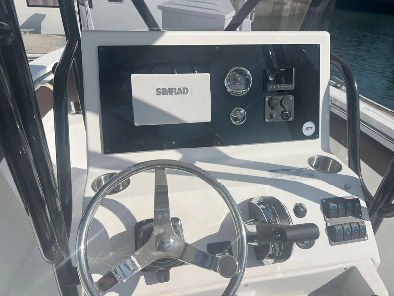 Slide: The Image of Control panel of Reflex Gladiator 2400 boat, featuring Simrad electronics, steering wheel, and gauges. - 24