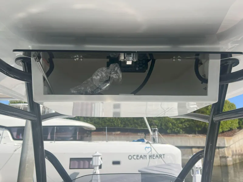 Slide: The Image of Underneath view of Reflex Gladiator 2400 boat, showcasing electronic components, docked near "Ocean Heart." - 27