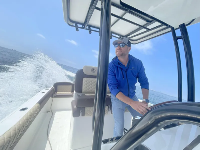 Slide: The Image of Man steering Reflex Gladiator 2400 boat on open water, 2026 model, under clear blue sky. - 30