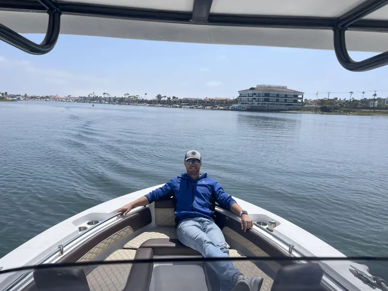 Slide: The Image of Man relaxing on a 2026 Reflex Gladiator 2400 boat, enjoying a sunny day on the water. - 31