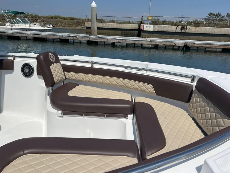 Slide: The Image of Luxurious seating on a 2026 Reflex Gladiator 2400 boat, docked by the water. - 46