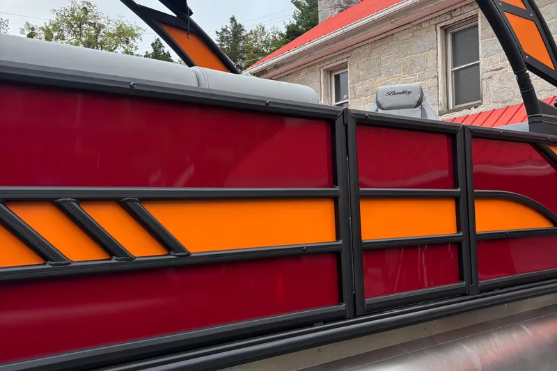 Slide: The Image of 2026 Bentley Pontoons Elite 223 Swingback with vibrant red and orange paneling. - 6