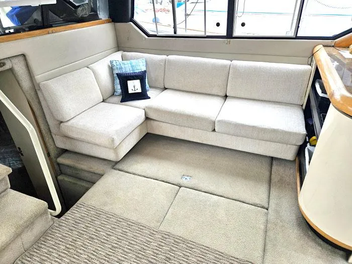 Slide: The Image of Interior of 1990 Bayliner 4387 Motoryacht with beige L-shaped sofa and nautical decor. - 11