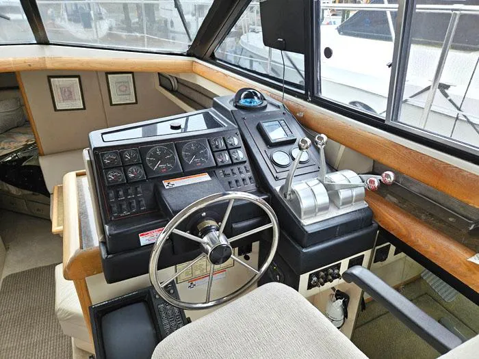 Slide: The Image of 1990 Bayliner 4387 Motoryacht helm with steering wheel and control panel. - 14