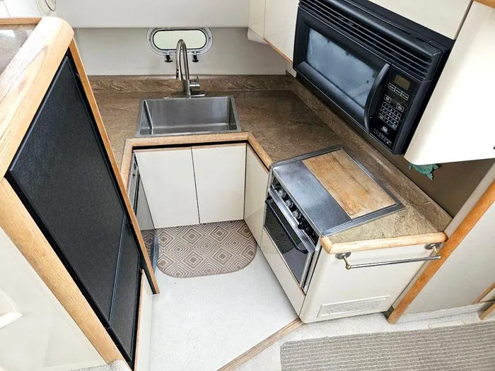 Slide: The Image of Compact kitchen in 1990 Bayliner 4387 Motoryacht with sink, stove, and microwave. - 16