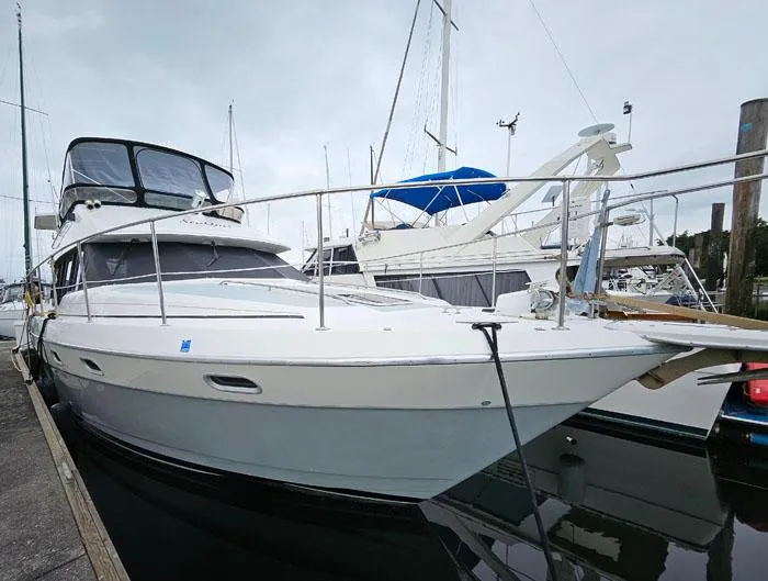 Slide: The Image of 1990 Bayliner 4387 Motoryacht docked at marina, overcast sky. - 2