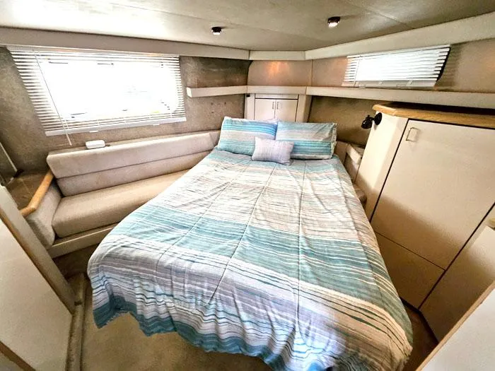 Slide: The Image of Cozy bedroom in 1990 Bayliner 4387 Motoryacht with striped bedding and ample natural light. - 21