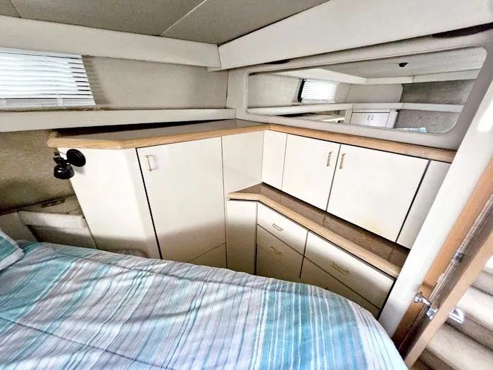 Slide: The Image of Interior of 1990 Bayliner 4387 Motoryacht with cabinets and bed, featuring modern design. - 22