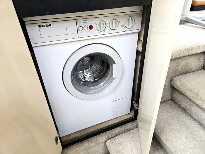 Slide: The Image of Kariba washing machine inside 1990 Bayliner 4387 Motoryacht, near carpeted stairs. - 25