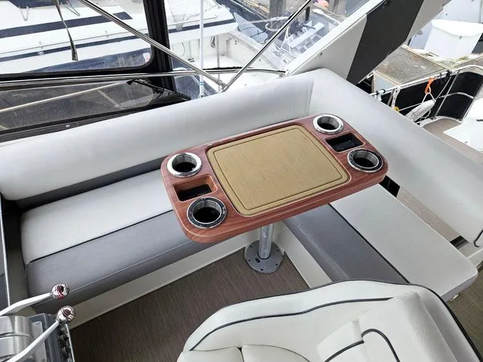 Slide: The Image of Interior seating area of 1990 Bayliner 4387 Motoryacht with table and cup holders. - 6