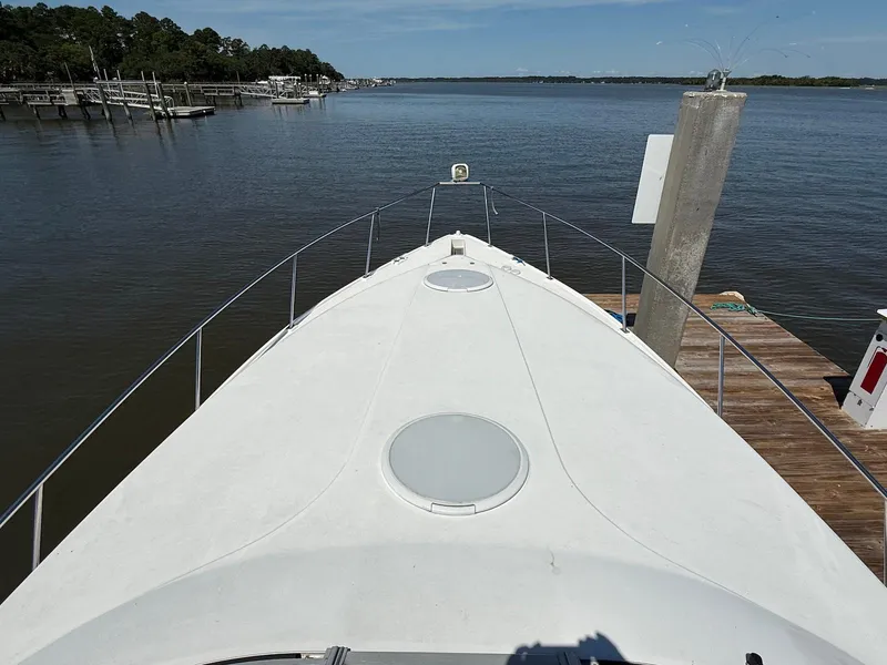 Slide: The Image of Bow view of 2000 Cruisers Yachts 3375 Express docked by calm waters. - 13