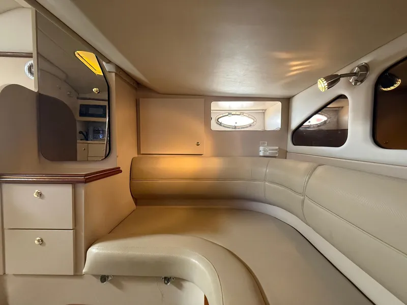 Slide: The Image of Interior of 2000 Cruisers Yachts 3375 Express, featuring beige seating and cabinetry. - 14