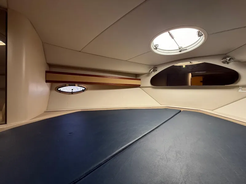 Slide: The Image of Interior cabin of 2000 Cruisers Yachts 3375 Express with portholes and blue cushioned seating. - 25