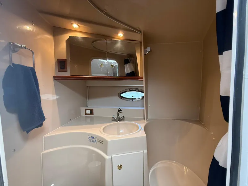 Slide: The Image of 2000 Cruisers Yachts 3375 Express bathroom with sink, mirror, and towel rack. - 28
