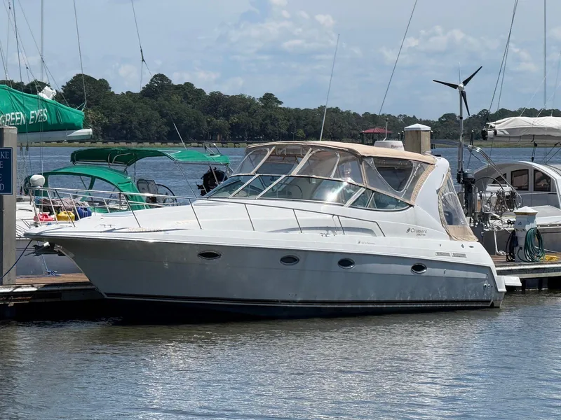 The Image of 2000 Cruisers Yachts 3375 Express docked at marina, sunny day, calm water. - 0
