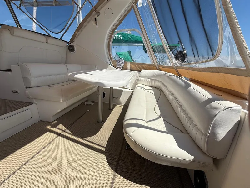 Slide: The Image of Interior of 2000 Cruisers Yachts 3375 Express with white seating and table. - 12