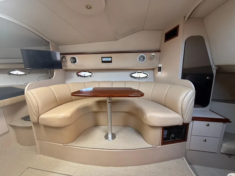 Slide: The Image of Interior of 2000 Cruisers Yachts 3375 Express with beige seating and wooden table. - 17