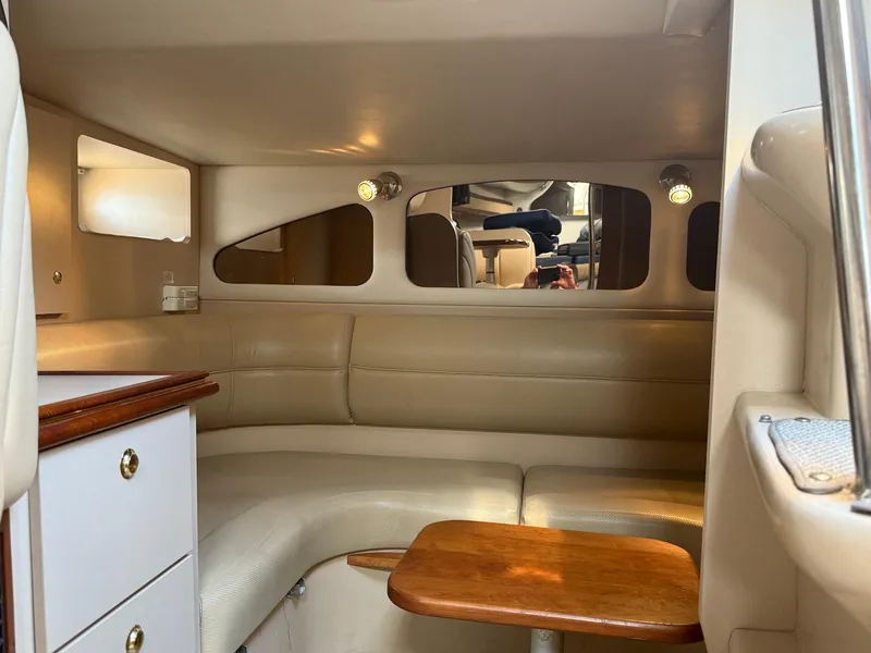 Slide: The Image of Interior of 2000 Cruisers Yachts 3375 Express with beige seating and wooden table. - 21