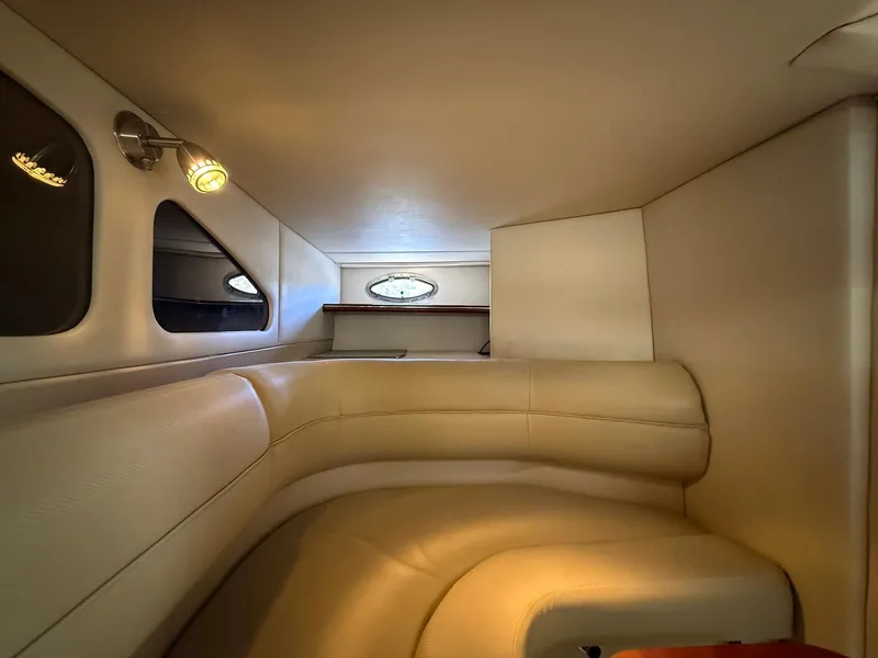 Slide: The Image of Interior cabin of 2000 Cruisers Yachts 3375 Express with beige seating and porthole windows. - 22