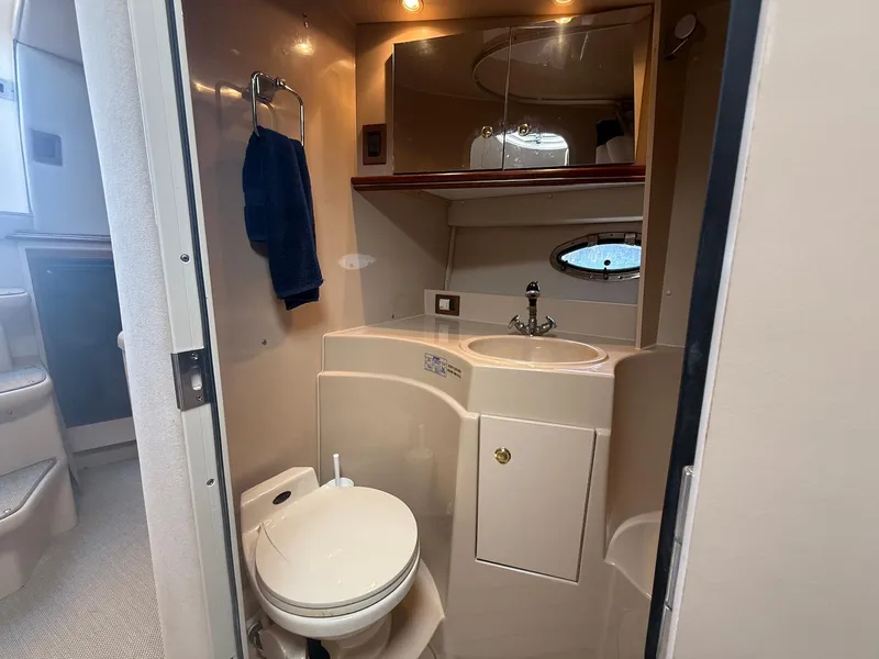 Slide: The Image of Bathroom interior of 2000 Cruisers Yachts 3375 Express, featuring sink, toilet, and mirror. - 29
