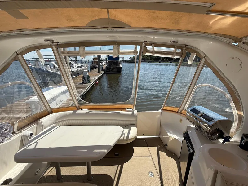 Slide: The Image of Interior view of 2000 Cruisers Yachts 3375 Express, featuring seating and table, docked by the water. - 8