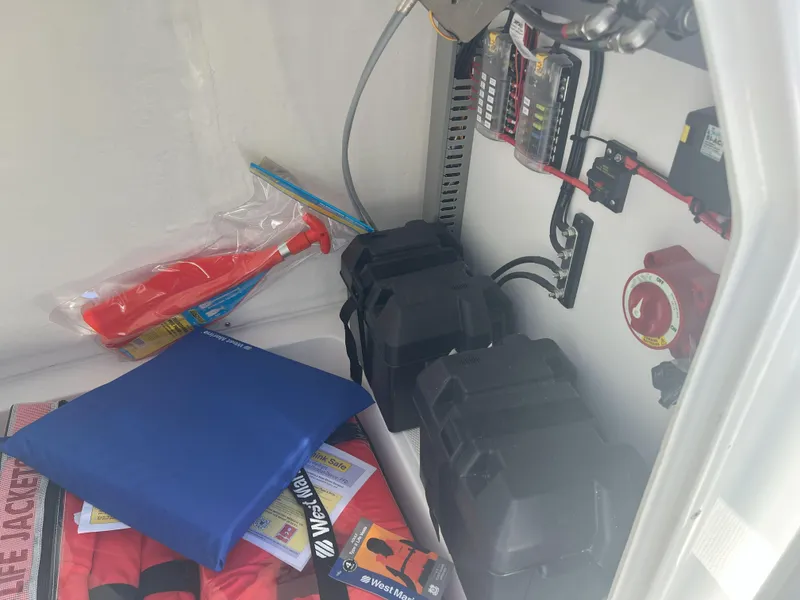 Slide: The Image of Storage compartment of Reflex Gladiator 2400 boat with safety equipment and electrical components, 2026 model. - 19